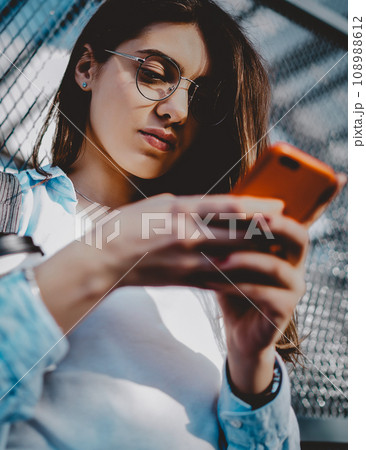 Young woman chatting on mobile phone in social networks 108988612