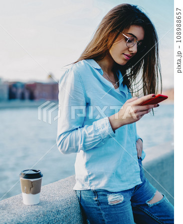 Charming casual dressed young woman enjoying trip Charming casual dressed young woman enjoying trip 108988657