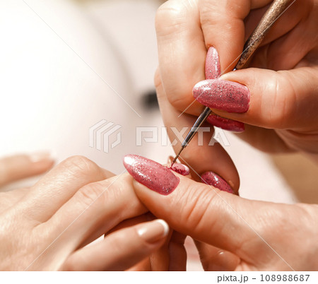 Master of manicure paints nails. Selective focus Master of manicure paints nails. Selective focus 108988687