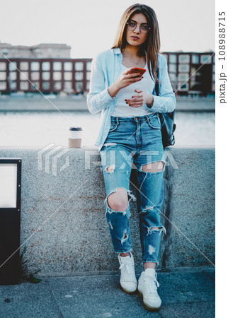 Charming hipster girl tourist standing in urban setting Charming hipster girl tourist standing in urban setting 108988715