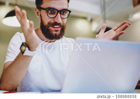 cheerful caucasian male freelancer satisfied with online earnings banking on netbook 108988838
