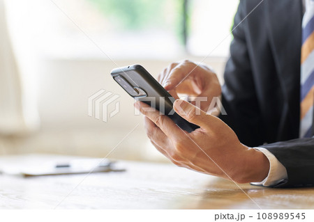 スマートフォンを使うビジネスマンの手元 108989545