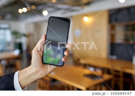 カフェでスマートフォンを使うビジネスマンの手元 108989547