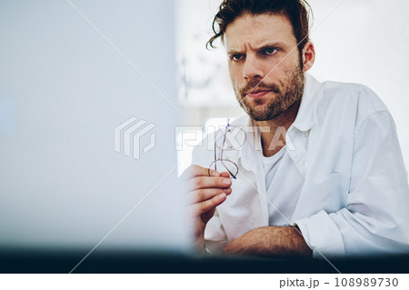 Serious concentrated businessman read news from exchange online via laptop computer Serious concentrated businessman read news from exchange online via laptop computer 108989730