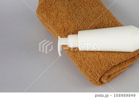 brown towel and shower gel on a gray background. face cream and towel on the table. Cosmetics SPA branding layout. Folded cream and bath towels on a white background. brown towel and shower gel on a gray background. face cream and towel on the table. Cosmetics SPA branding layout. Folded cream and bath towels on a white background. 108989849