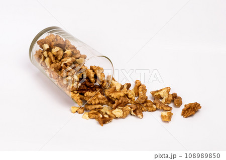 Walnuts in a glass. Scattered peeled nuts. Glass jar with peeled walnuts. Walnuts in a glass. Scattered peeled nuts. Glass jar with peeled walnuts. 108989850