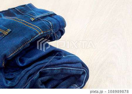 Blue jeans on a white background. Lots of jeans. Denim close-up. Fashionable blue stylish clothes. Pressed jeans. Jeans store. 108989878