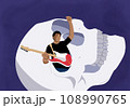 Guitar rocker man standing inside the eye of skull 108990765