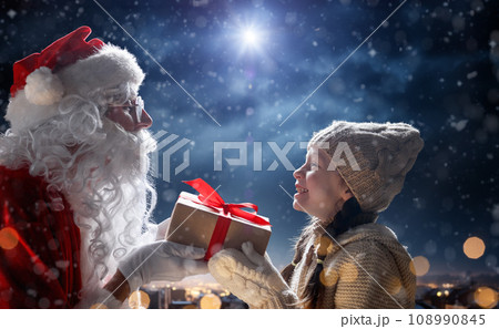 child girl and Santa Claus with gift child girl and Santa Claus with gift 108990845