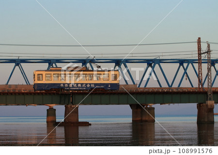 夕闇迫る日本海を背景に庄川を渡る富山地方鉄道デ7000形電車_2023/11/4撮影 108991576