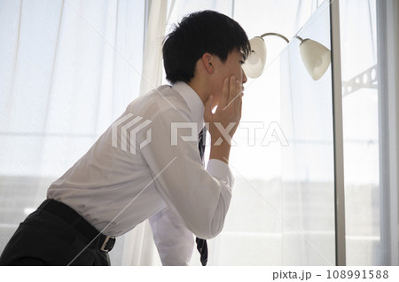 自宅の鏡で顏を気にする中学生の男の子 108991588