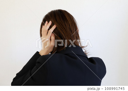 頭を抱えるスーツの女性 108991745