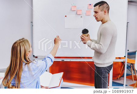 Two designers discussing plan written on board Two designers discussing plan written on board 108991937