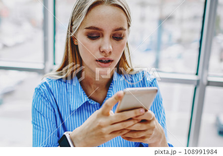 Positive hipster girl chatting on digital cellular device 108991984