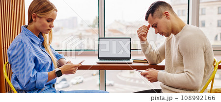 Two antisocial young man and woman from millennial generation ignoring live communication Two antisocial young man and woman from millennial generation ignoring live communication 108992166