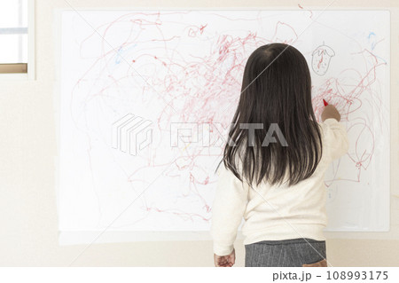 壁のホワイトボードに落書きする女の子の後ろ姿（3歳、日本人） 108993175