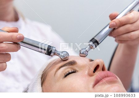 Close up of woman at professional microcurrent procedure. Hardware cosmetology and skin care 108993633