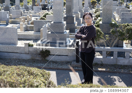 墓参りに来て考え込んでいる中高年女性 墓参りに来て考え込んでいる中高年女性 108994307
