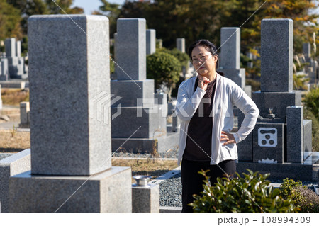 墓参りに来て考え込んでいる中高年女性 108994309