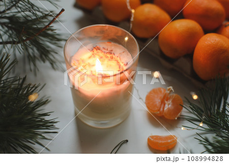 Candle, tangerines and pine. Christmas background with fir tree branches and tangerines merry christmas and happy new year. Candle, tangerines and pine. Christmas background with fir tree branches and tangerines merry christmas and happy new year. 108994828