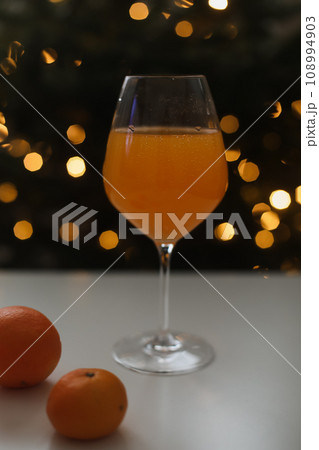 tangerine or orange juice with tangerines on the Christmas tree background tangerine or orange juice with tangerines on the Christmas tree background 108994903