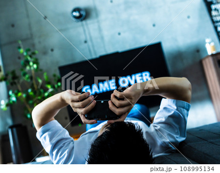 自宅でテレビゲームをする男性 108995134