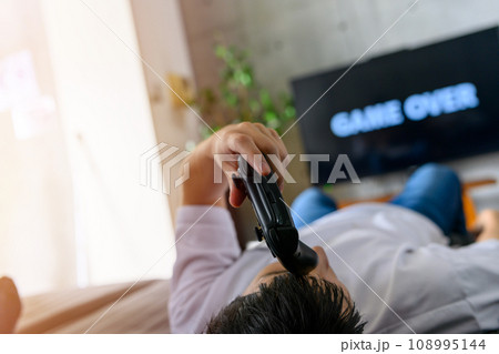 自宅でテレビゲームをする男性 108995144