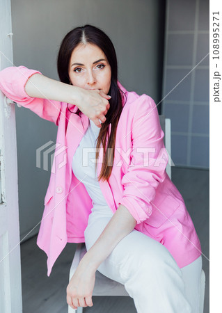 Beautiful brunette woman in white suit and pink jacket 108995271