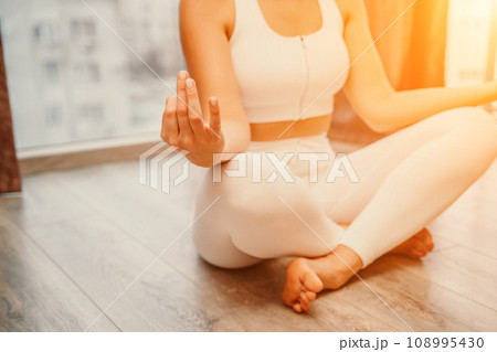 Young woman meditating at home. Girl practicing yoga in class. Relaxation at home, body care, balance, healthy lifestyle, meditation, mindfulness, recreation, workout, fitness, training concept Young woman meditating at home. Girl practicing yoga in class. Relaxation at home, body care, balance, healthy lifestyle, meditation, mindfulness, recreation, workout, fitness, training concept 108995430