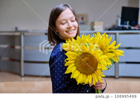 Young happy woman with bouquet of yellow sunflower 108995499