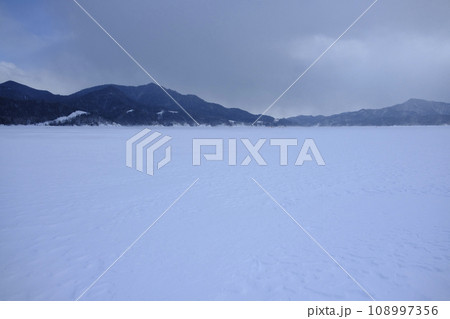 冬の凍結した糠平湖の湖面から見る風景 108997356