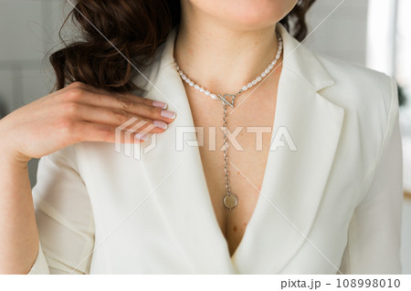 Woman's decollete with a luxury jewelry. Unusual and elegant pendant. Close up shot of beautiful pendant with crystals. Women Accessories. Woman's decollete with a luxury jewelry. Unusual and elegant pendant. Close up shot of beautiful pendant with crystals. Women Accessories. 108998010