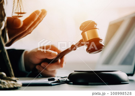 Business and lawyers discussing contract papers with brass scale on desk in office. Law, legal services, advice, justice and law concept picture with film grain effect Business and lawyers discussing contract papers with brass scale on desk in office. Law, legal services, advice, justice and law concept picture with film grain effect 108998528