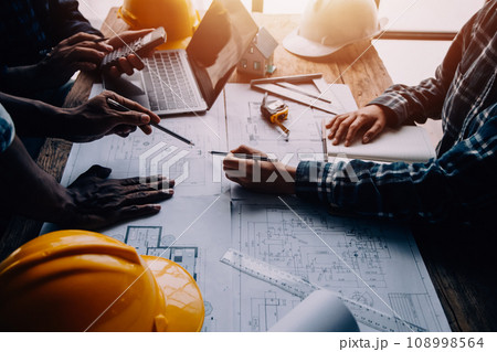 Construction and structure concept of Engineer or architect meeting for project working with partner and engineering tools on model building and blueprint in working site, contract for both companies. 108998564