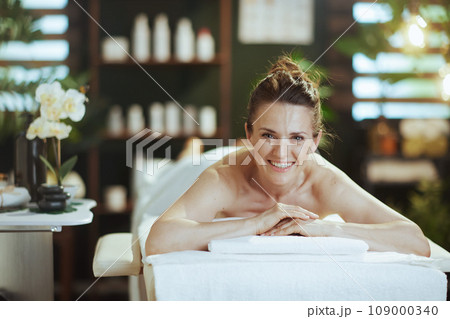 happy modern female in massage cabinet laying on massage table happy modern female in massage cabinet laying on massage table 109000340
