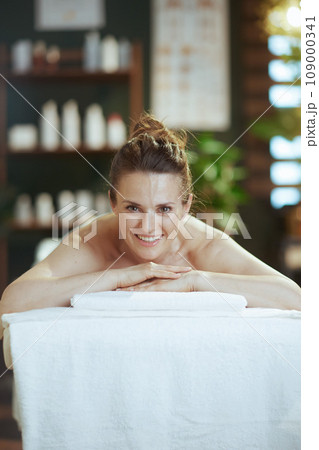 smiling modern woman in massage cabinet laying on massage table smiling modern woman in massage cabinet laying on massage table 109000341
