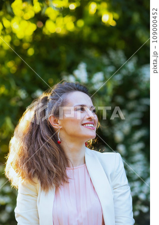 happy modern woman in pink dress and white jacket in city happy modern woman in pink dress and white jacket in city 109000452