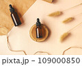 Hand making DIY scene. Glass amber bottles with black cap flat lay. Beauty products packaging. Dropper bottle with pipette on wooden podium. Natural eco-friendly cosmetics presentation with copy space 109000850