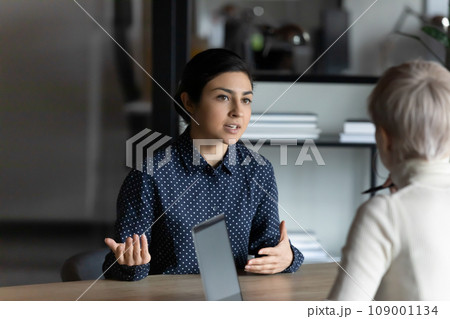 Serious female Indian job candidate speaking to employer 109001134