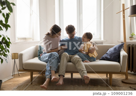 Smiling family spend time together at home sit on sofa Smiling family spend time together at home sit on sofa 109001236