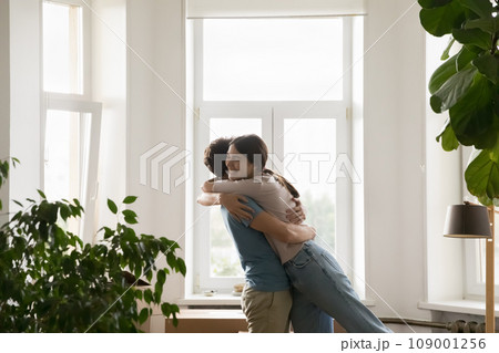 Overjoyed loving young spouses cuddling celebrating relocation day Overjoyed loving young spouses cuddling celebrating relocation day 109001256