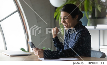 Happy excited Indian employee, business woman reading message on screen 109001311