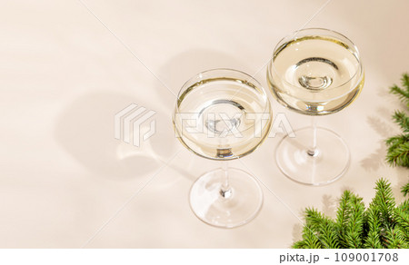 Two champagne glasses on a beige Two champagne glasses on a beige 109001708