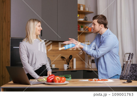 Leave Me Alone. A woman is preparing food, and a man is talking to her, and is not satisfied with the way she is cooking. 109001763