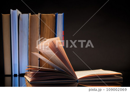open book for reading and a stack of books open book for reading and a stack of books 109002069