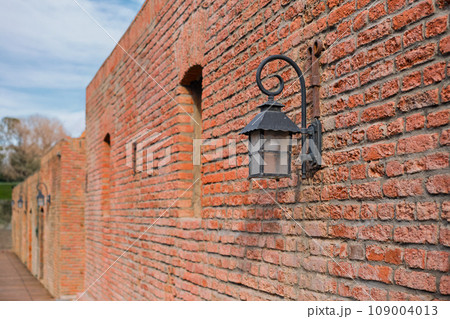 Wall of red brick baths and street lamps in the old town in Tbilisi in the sunset sunlight, idea for background and article about the city Wall of red brick baths and street lamps in the old town in Tbilisi in the sunset sunlight, idea for background and article about the city 109004013