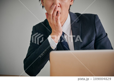 眠くてあくびをする若い男性会社員 眠くてあくびをする若い男性会社員 109004829