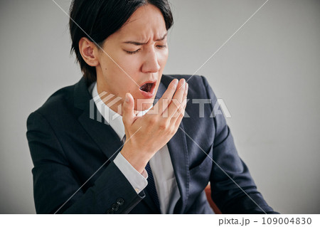 眠くてあくびをする若い男性会社員 109004830