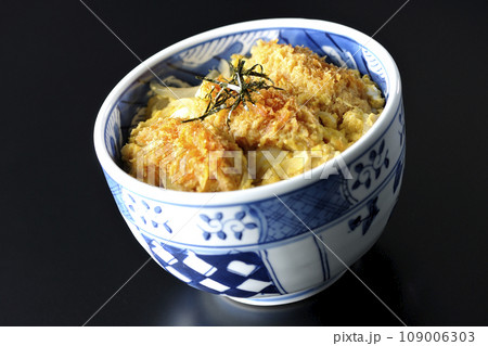 牡蠣フライ卵とじ丼を黒背景で撮影 109006303