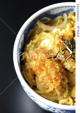 牡蠣フライ卵とじ丼を黒背景で俯瞰撮影 109006364